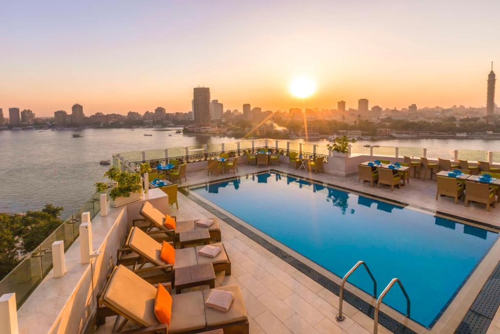 a hotel pool with a view of the river at Kempinski Nile Hotel, Cairo in Cairo