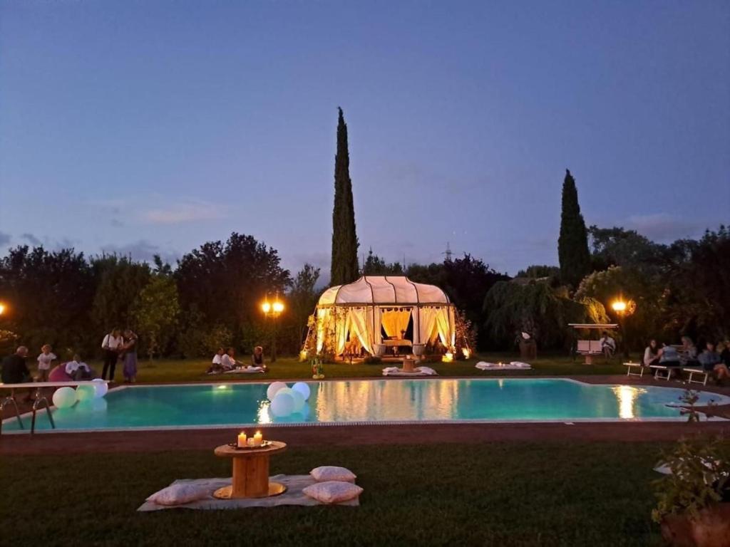 a gazebo next to a swimming pool at night at Villa Fiore Luxury Pool & Garden in Pisa