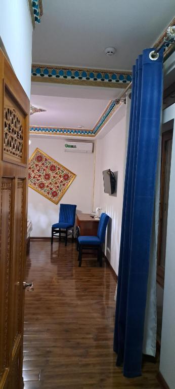 a room with two blue chairs and a table at Hotel Ansi Boutique W&S terrace in Bukhara