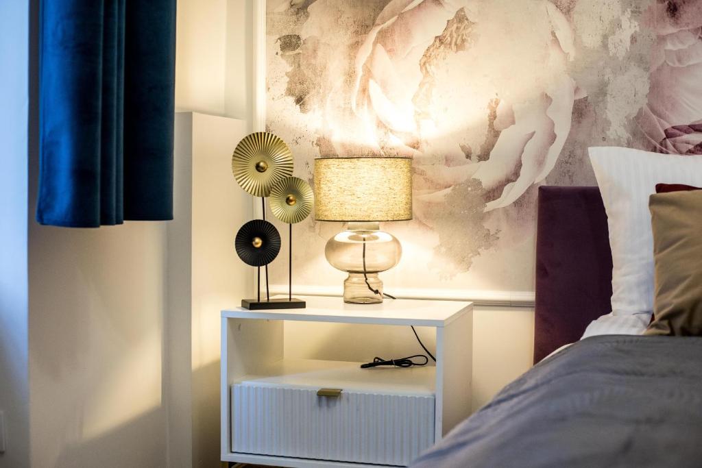 a nightstand with a lamp on it next to a bed at CracWoW K8 No.6 Apartment in Krakow