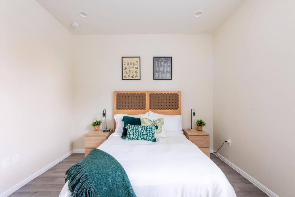 a bedroom with a large white bed with green pillows at Cozy Condo in Round Rock in Round Rock
