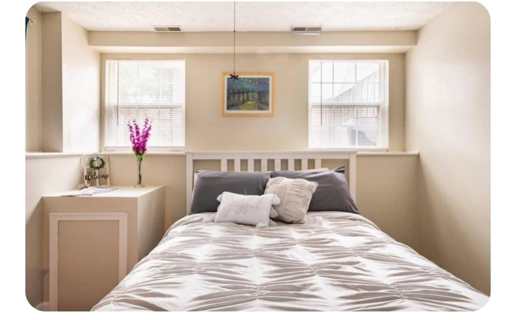 a bedroom with a bed and two windows at Hidden Gem near Downtown Frederick and shopping in Frederick