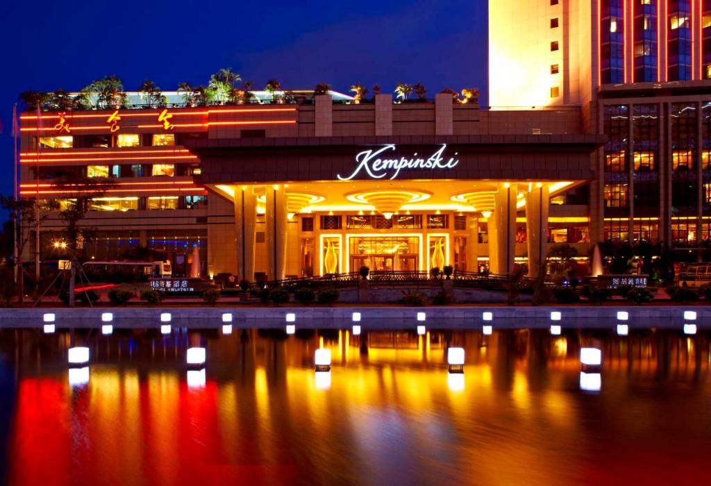 a building with a sign on the side of it at night at Kempinski Hotel Shenzhen - 24 Hours Stay Privilege, Subject to Hotel Inventory in Shenzhen