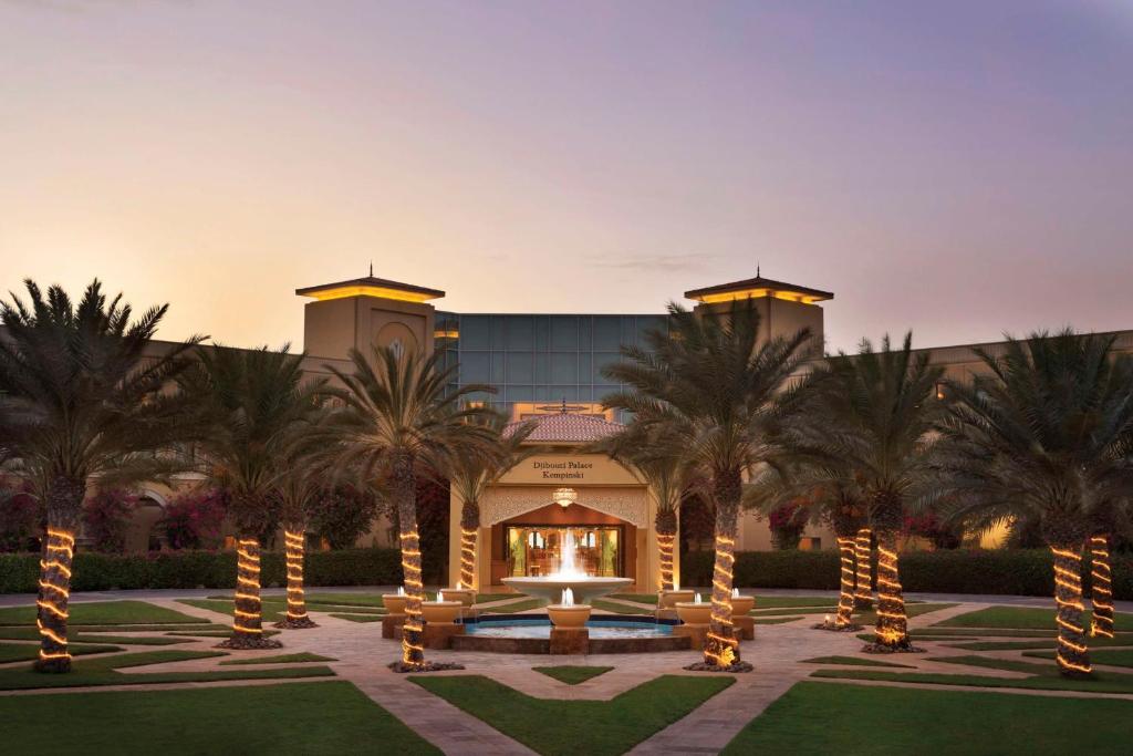 a resort with palm trees in front of a building at Djibouti Palace Kempinski in Djibouti