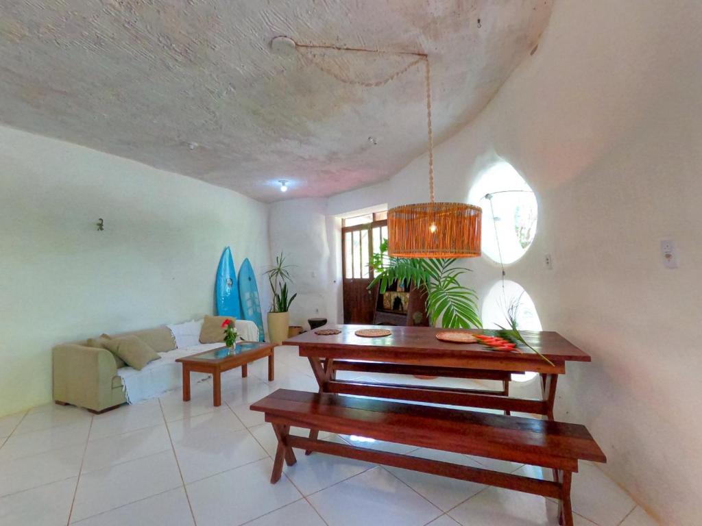 een woonkamer met een tafel en een bank bij Casa ecológica surf e natureza in Camassari