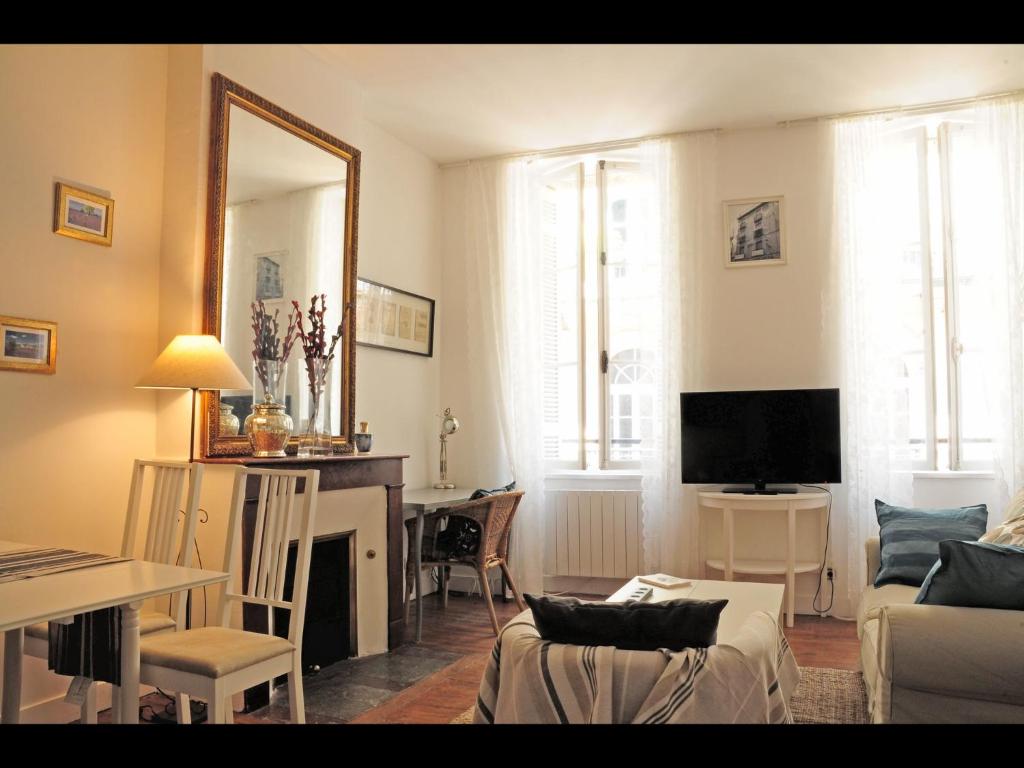 ein Wohnzimmer mit einem Sofa, einem Tisch und einem Spiegel in der Unterkunft Bordeaux charming center in Bordeaux