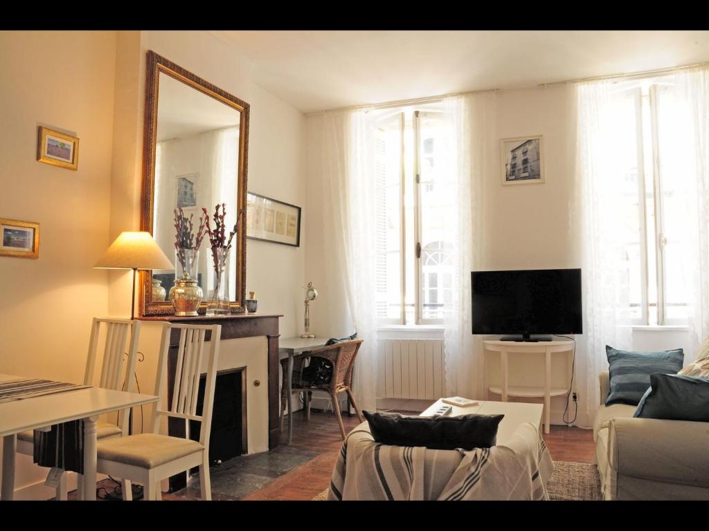 uma sala de estar com um sofá, uma mesa e um espelho em Bordeaux charming center em Bordeaux