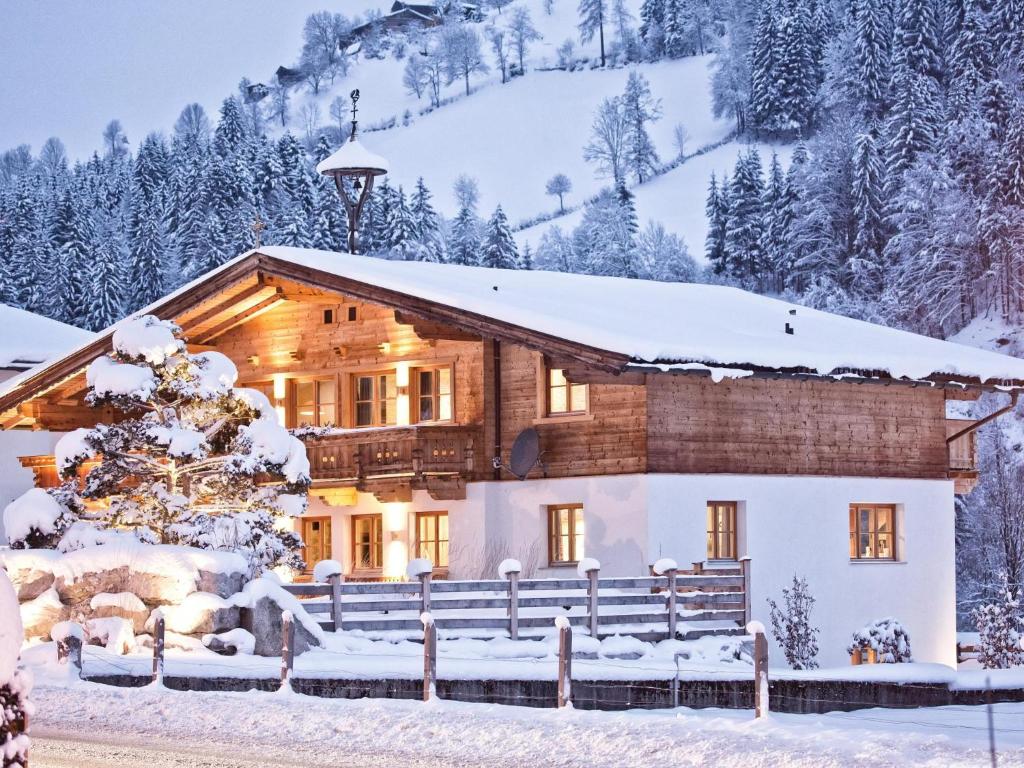 uma cabana de madeira na neve com neve em Chalet-Apartment Lavendel am Lift em Kirchberg in Tirol