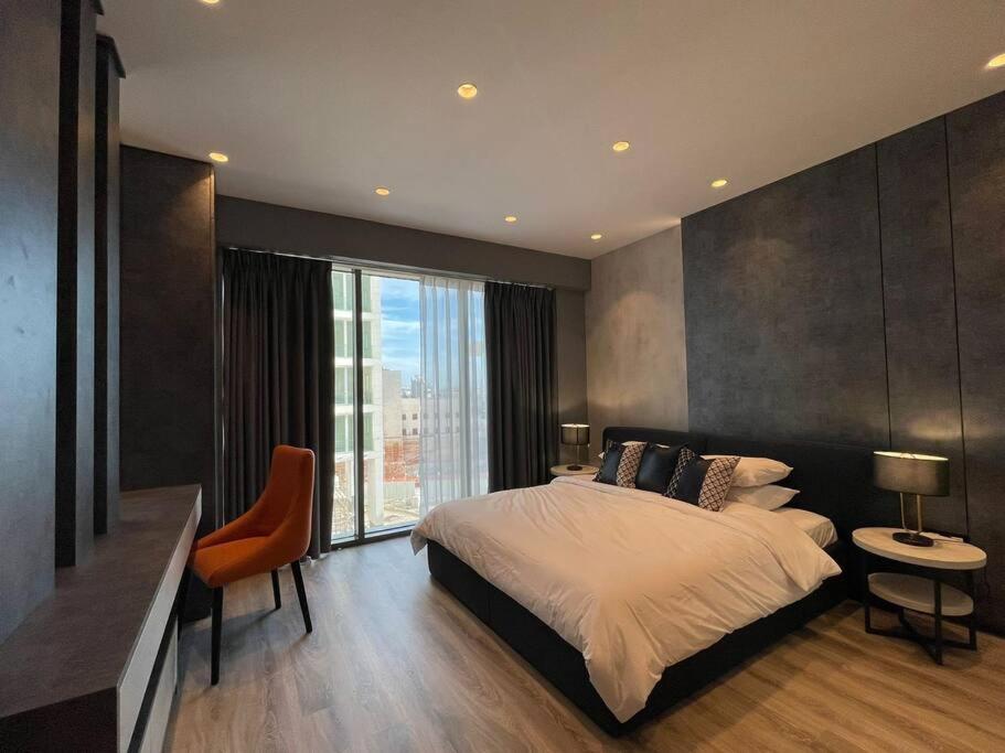 ein Schlafzimmer mit einem großen Bett und einem großen Fenster in der Unterkunft Damac Properties AmmanLuxury Furnished Apartment in Amman