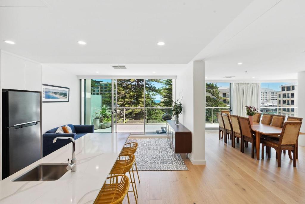 a kitchen and living room with a table and chairs at Belle Escapes - Sea the Views in Glenelg
