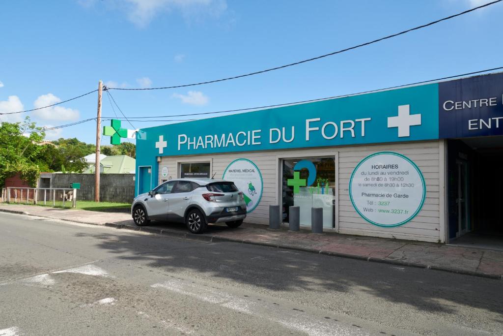 a car parked in the front of a pharmacy dmgermottermottermott at fleur de tranquillité in Le Gosier