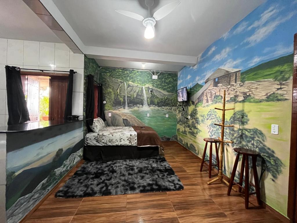 1 dormitorio con un mural en la pared en Casa Do Guh, en São Thomé das Letras