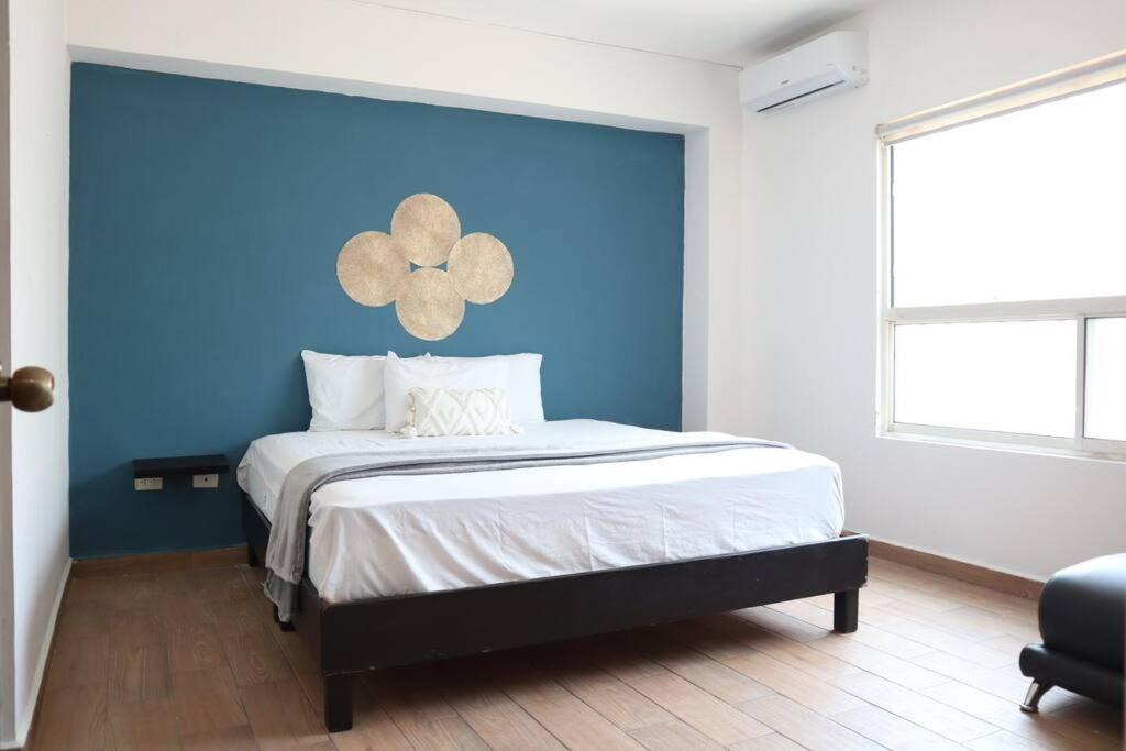 a bedroom with a blue wall and a bed at Linda Vista, la mejor ubicación, 5 min Fundidora - LV2 - in Monterrey