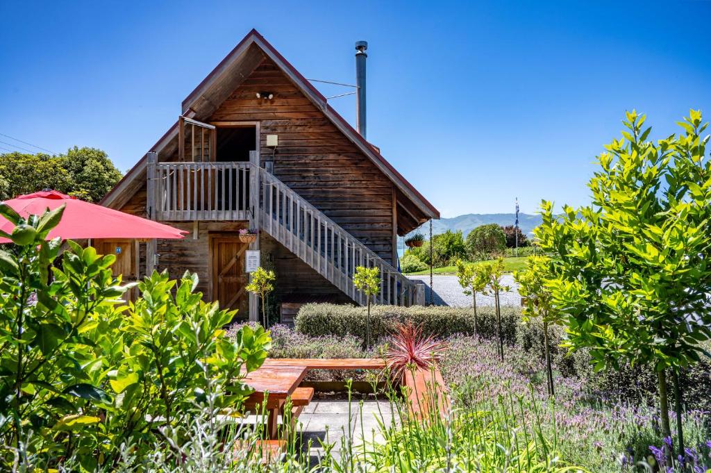 a log cabin with a picnic table in the garden at French Peak Loft - French Farm Holiday Home in Taihape