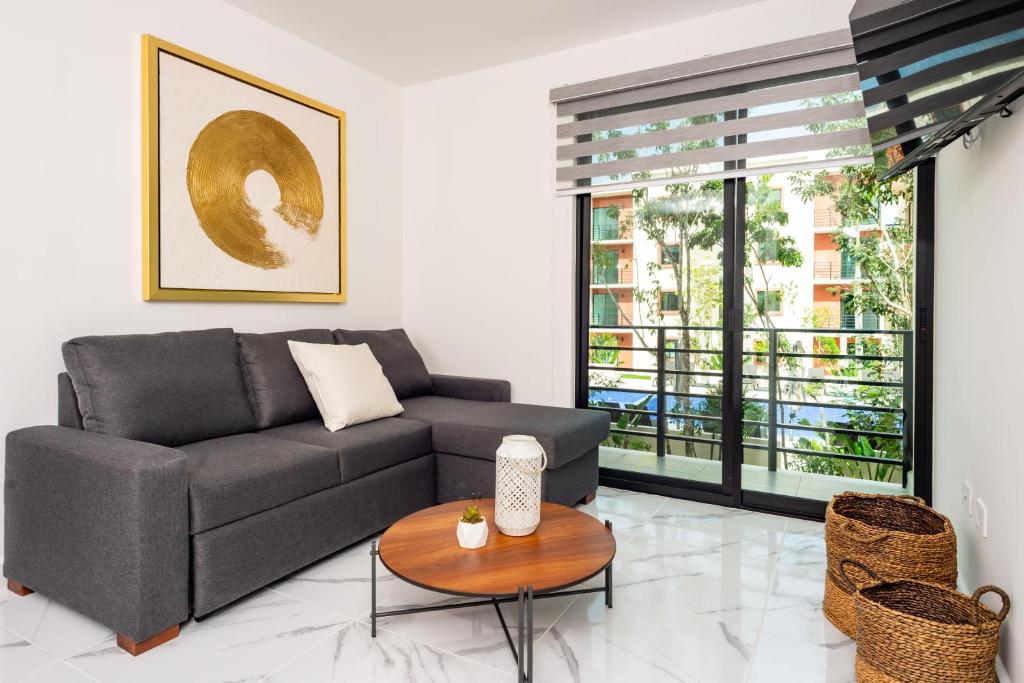 - un salon avec un canapé et une table dans l'établissement 2BR Moderno en residencial Ombu, à Cancún