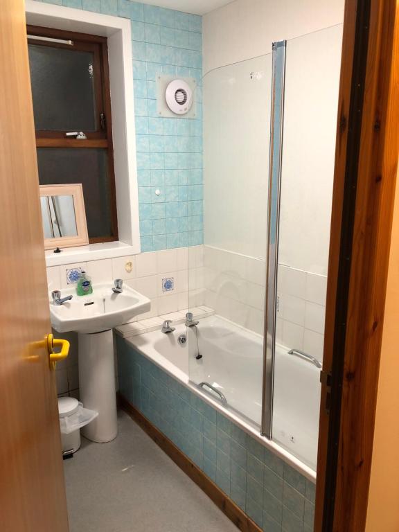 a bathroom with a tub and a sink and a toilet at Cosy flat, Scalloway in Scalloway