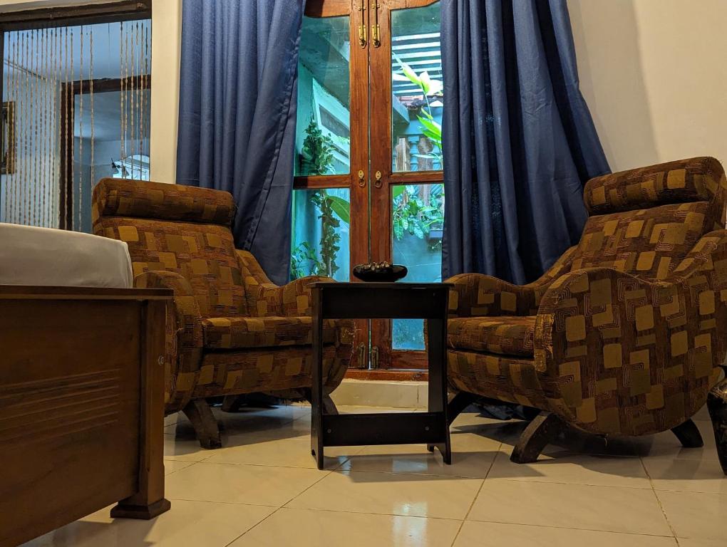 um quarto com duas cadeiras, uma mesa e uma janela em The Traditional Villa by ceyio em Matara