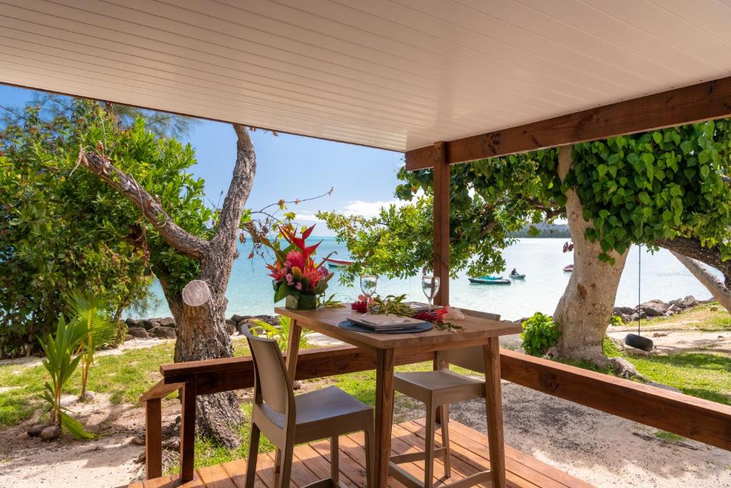 a table and chairs on a porch with a view of the ocean at Matira Beach Raitea 1 in Bora Bora