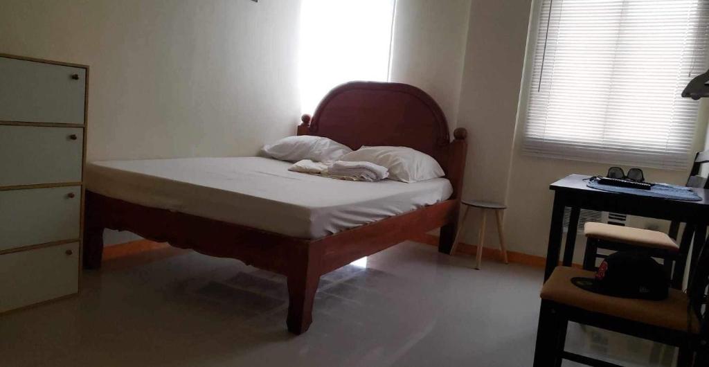 a small bedroom with a bed with white sheets at CRYSTAL CONDO RENTAL in Calamba