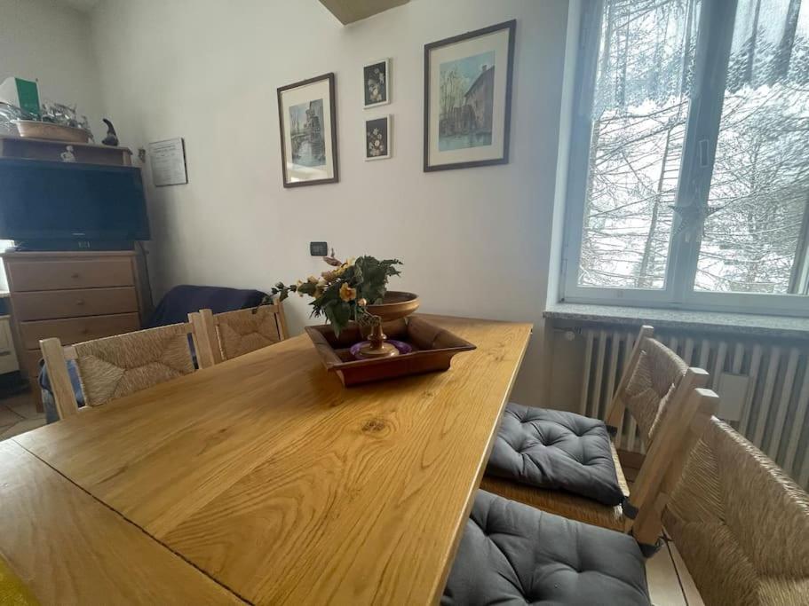 una mesa de madera en la sala de estar con mesa de comedor en Bilocale elegante a Pragelato en Pragelato