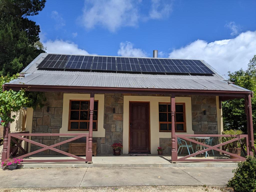 una piccola casa con pannelli solari sul tetto di Cottage in Uraidla a Uraidla