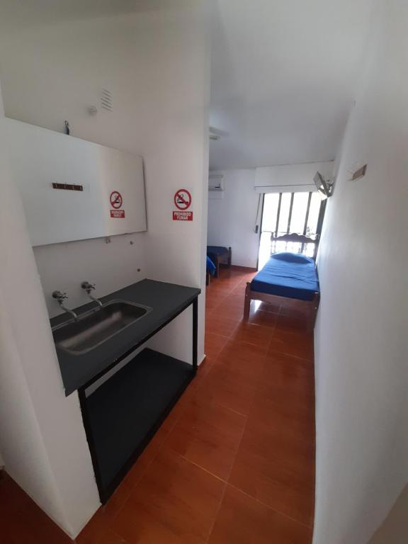 a bathroom with a sink and a bed in a room at 4 Ases Hotel in Embalse