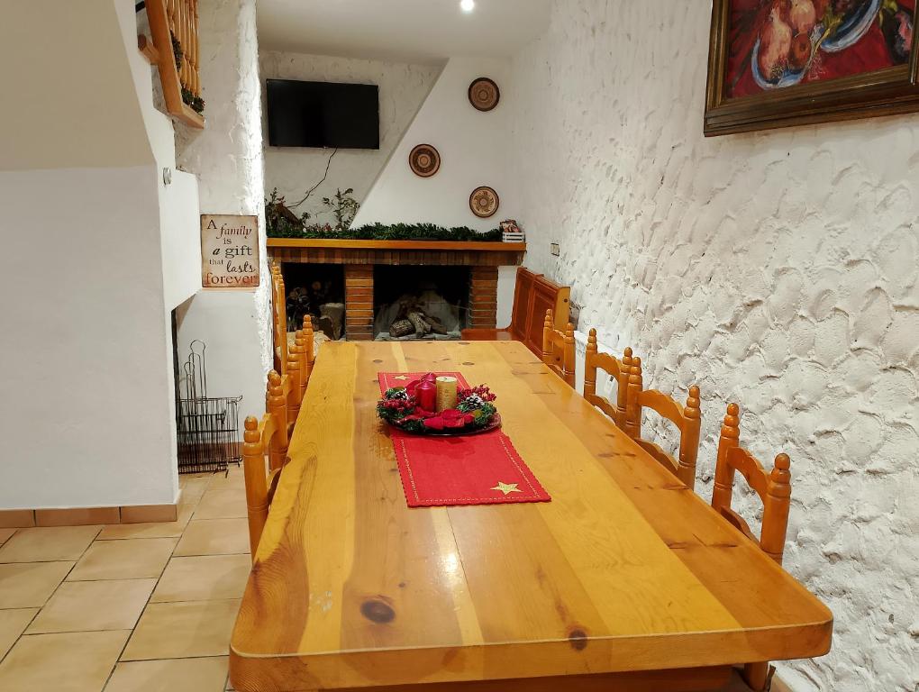 una larga mesa de madera en una habitación con chimenea en Cal Massana, en Sant Guim de la Plana