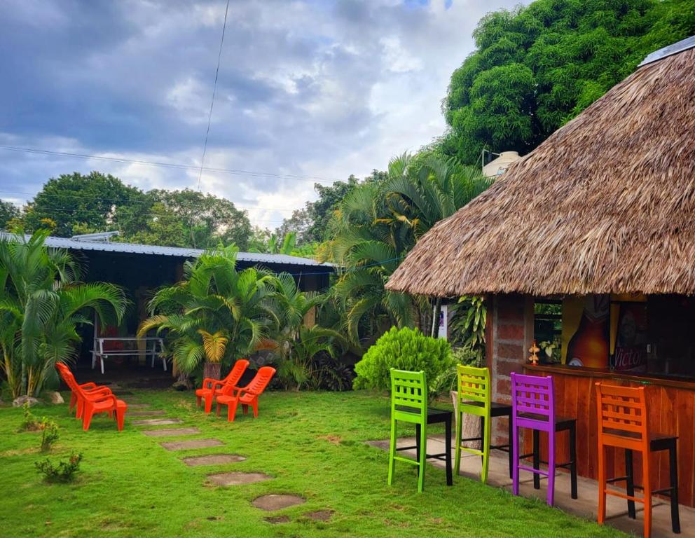 un groupe de chaises colorées devant une maison dans l'établissement Hostal Casa Mauro, à Moyogalpa