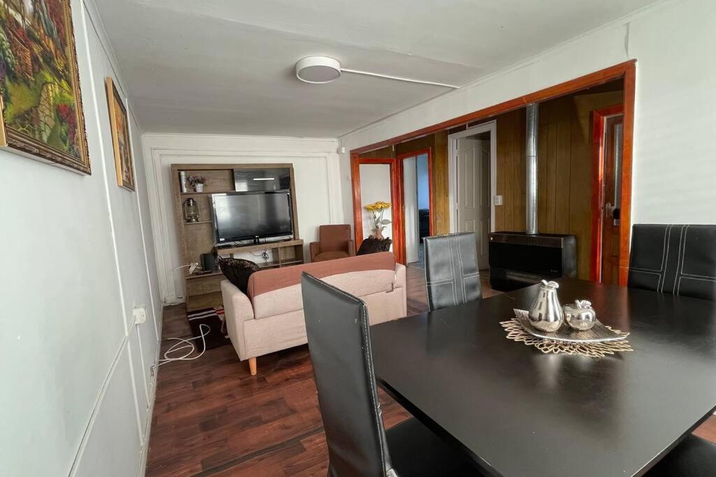 sala de estar con mesa de comedor y sofá en Casa en arriendo muy amplia con dos habitaciones en Punta Arenas