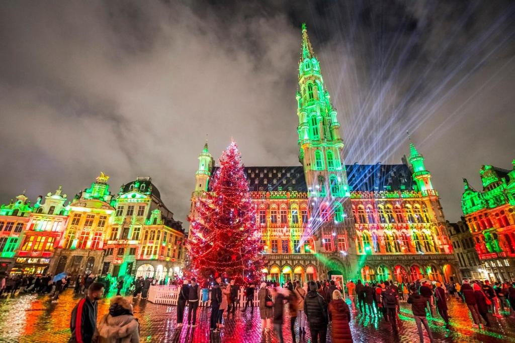 un arbre de Noël devant un bâtiment aux lumières de Noël dans l'établissement Appartement au cœur de Bruxelles, à Bruxelles