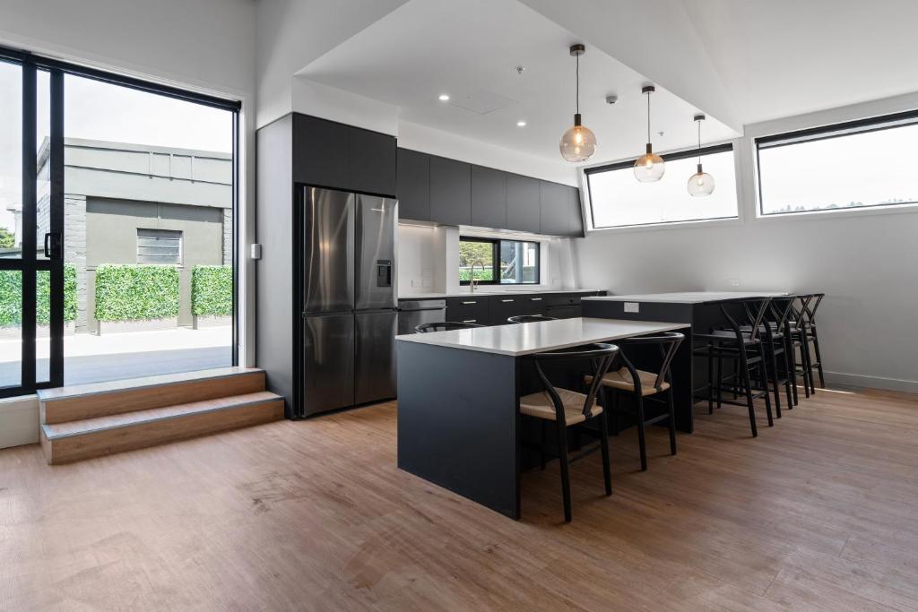 a kitchen with a black island with bar stools at The Chamberson in Dunedin