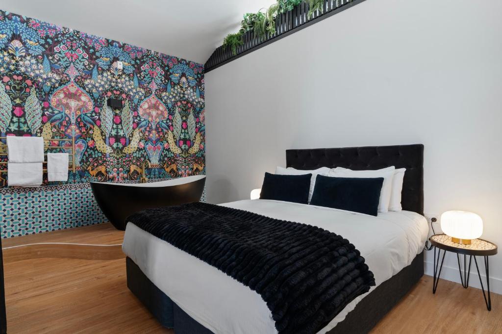 a bedroom with a large bed and a colorful wall at The Chamberson in Dunedin