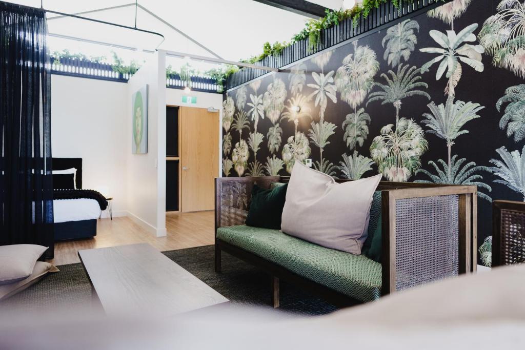 a living room with a couch and a wall with plants at The Chamberson in Dunedin