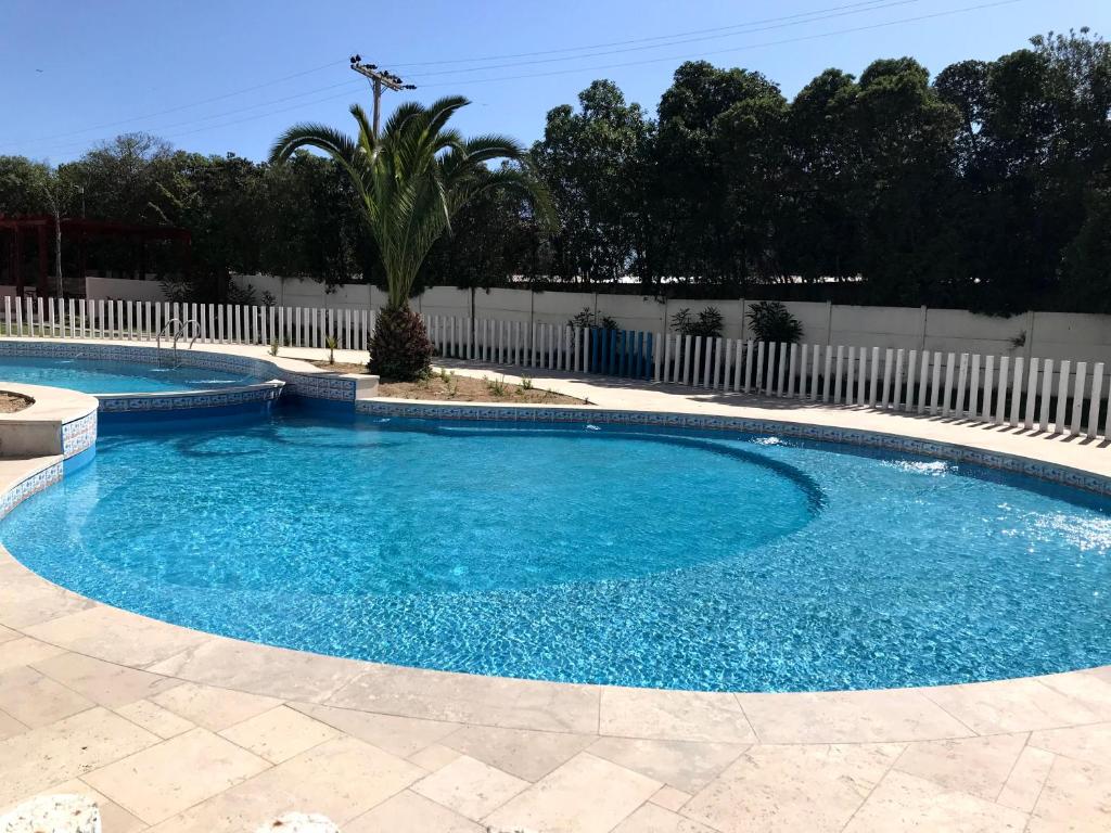 una piscina con agua azul y una valla blanca en Apartment La Serena Pacifico, en La Serena