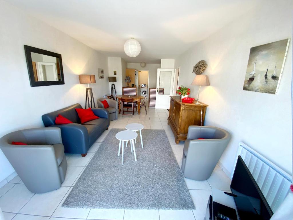 un salon avec un canapé et une table dans l'établissement Appartement Charmant avec Garage à 400 m de la Plage - FR-1-92-738, à Les Sables-dʼOlonne