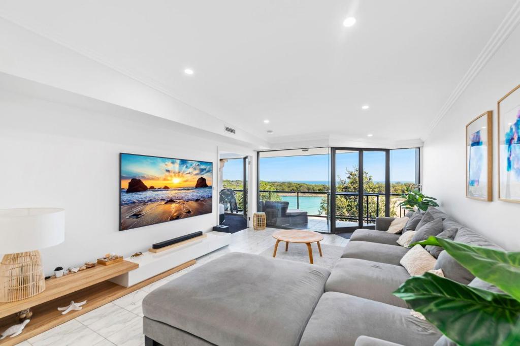 sala de estar con sofá y TV grande en Ocean Views, en Boat Harbour