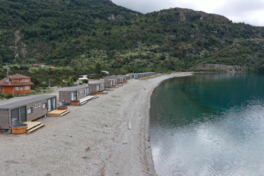 a beach with a bunch of buildings next to the water at Chelenko Lodge in Puerto Tranquilo