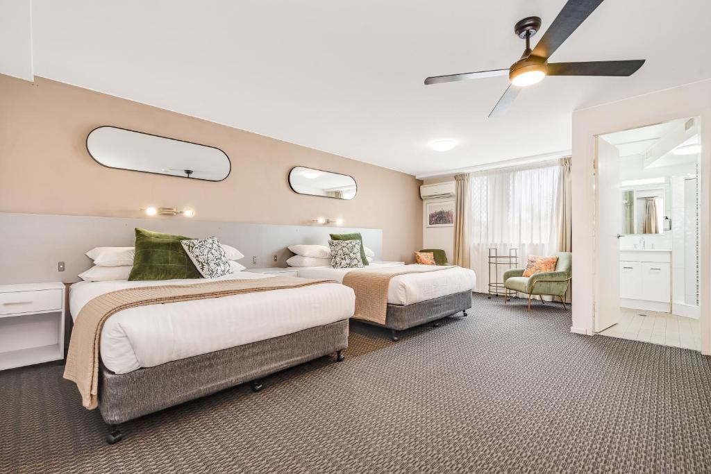 a bedroom with two beds and a ceiling fan at Elizabeth Motor Inn in Newcastle