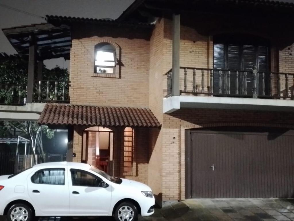 a white car parked in front of a house at Residencial Colling in Canela