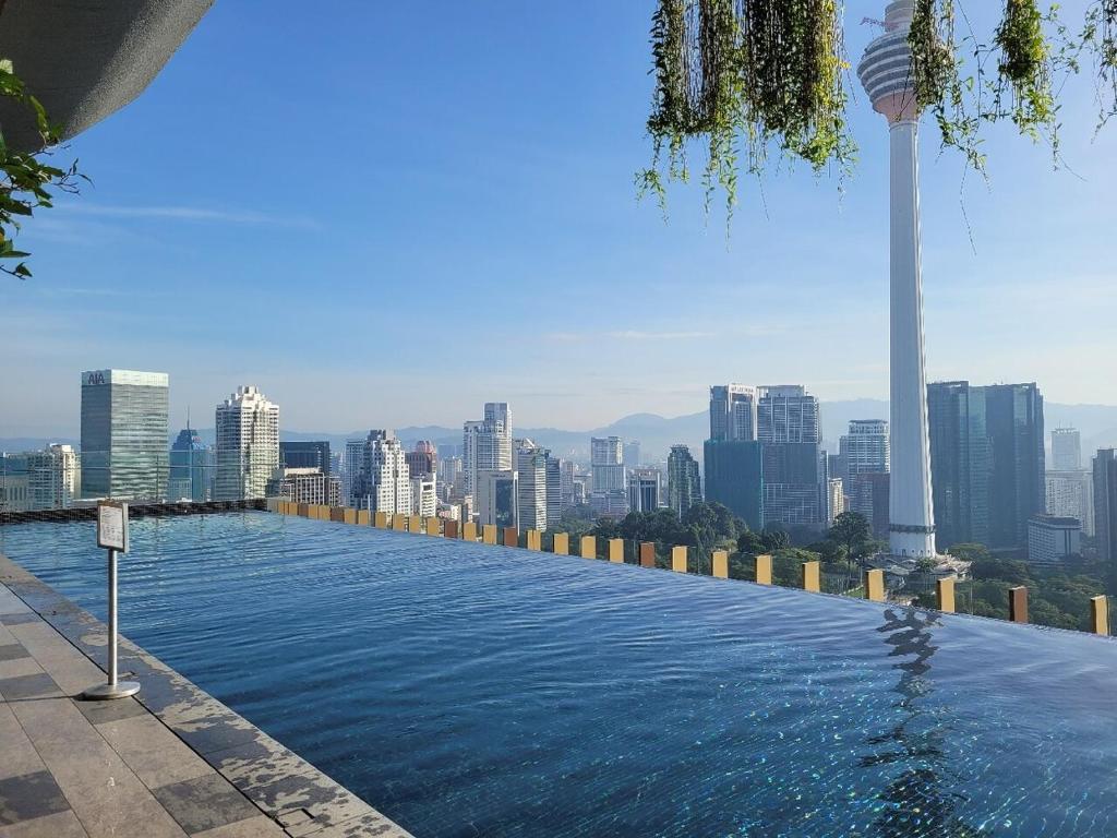 a swimming pool with a city skyline in the background at CeylonZ Suites by Plush in Kuala Lumpur
