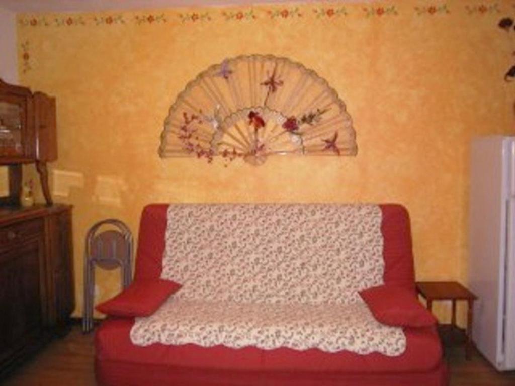 - un canapé rouge dans une chambre avec un mur dans l'établissement Studio skis aux pieds, 4 pers, balcon, commerces proches - FR-1-322-548, aux Orres
