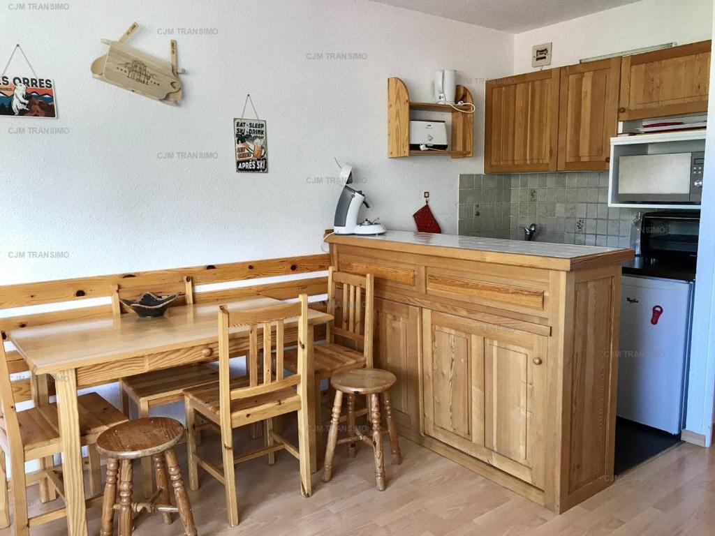 - une cuisine avec une table en bois et des chaises dans l'établissement Studio Les Orres, 1 pièce, 6 personnes - FR-1-322-554, aux Orres