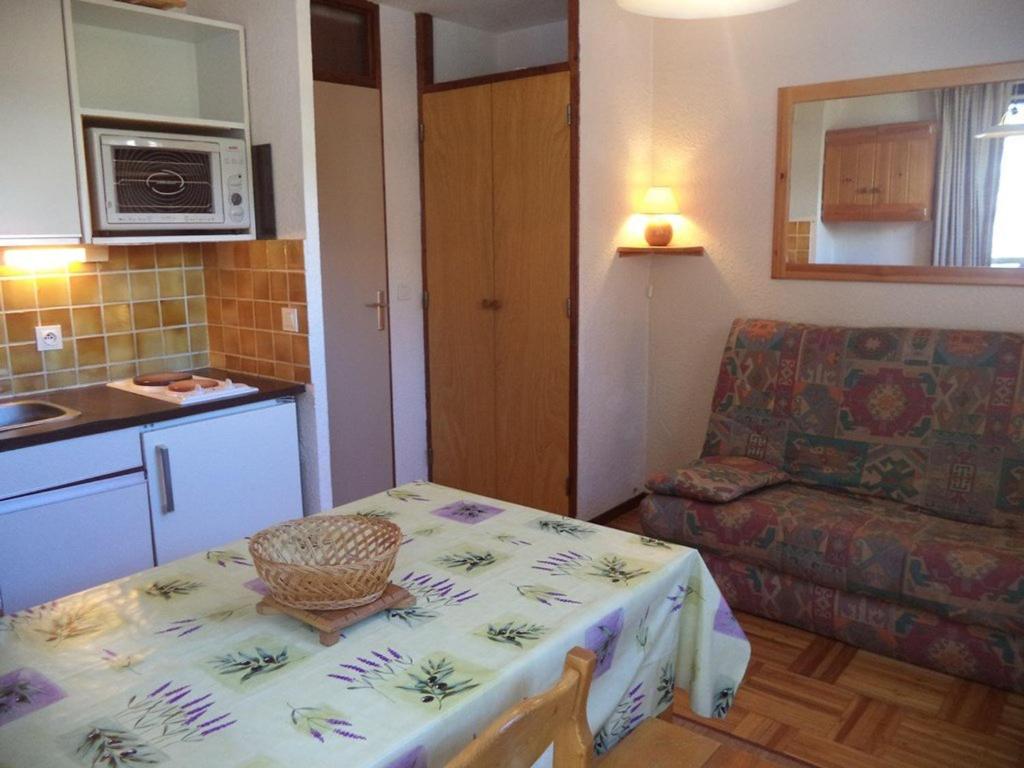 a small kitchen with a table and a couch at Studio Les Orres, 1 pièce, 4 personnes - FR-1-322-576 in Les Orres