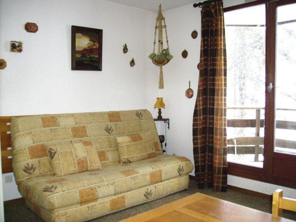 a living room with a couch and a window at Studio Les Orres, 1 pièce, 4 personnes - FR-1-322-579 in Les Orres