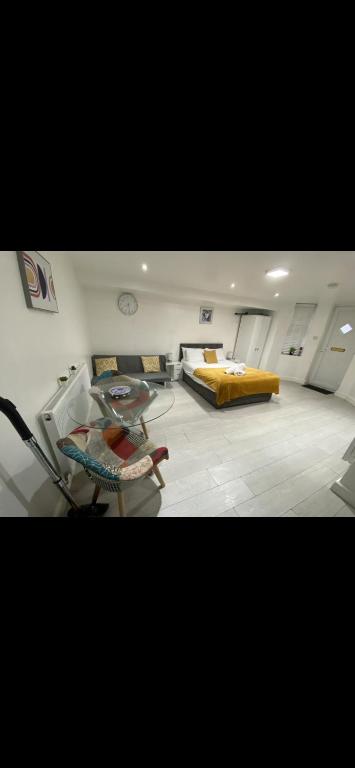 a living room with a glass table and a bed at St James Apartments in Leeds