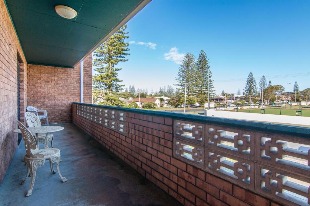 two chairs sitting on the balcony of a brick building at Seabreeze 3 in Tuncurry