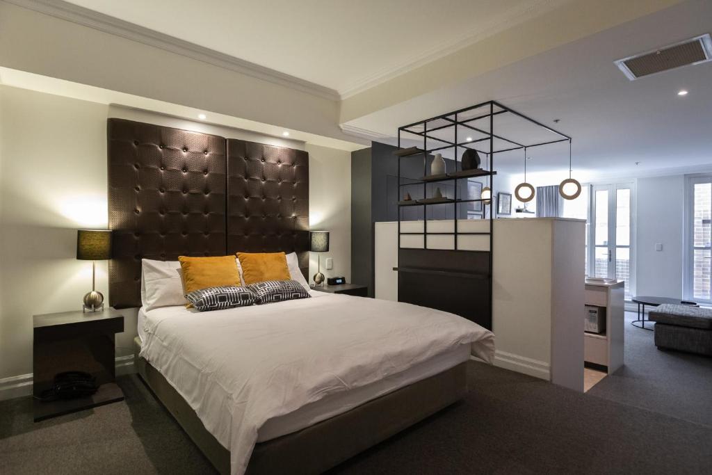 sypialnia z dużym łóżkiem z czarnym zagłówkiem w obiekcie CBD Executive Apartment right by the Harbour w mieście Sydney