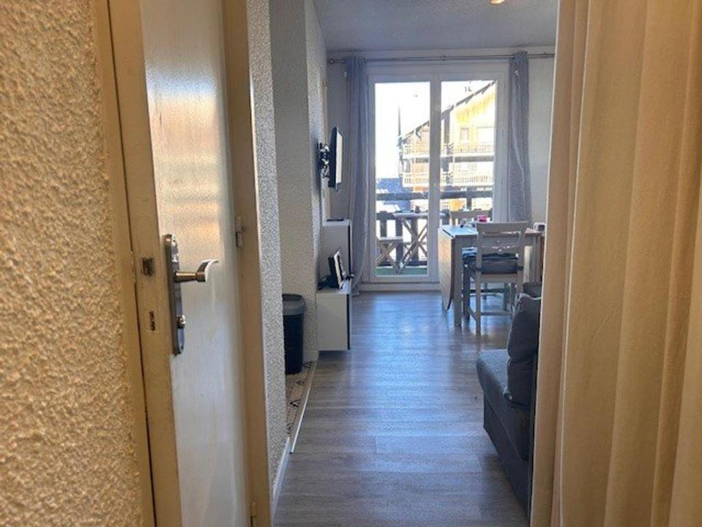 un couloir avec une porte s'ouvrant sur un salon dans l'établissement Studio Cabine 4 pers. à Risoul 1850, Accès Direct Pistes, Balcon, Piscine Chauffée l'Été - FR-1-330-575, à Risoul