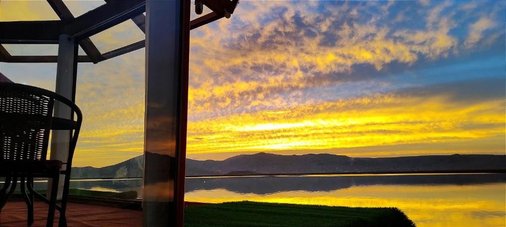 - une vue sur le coucher du soleil depuis une maison donnant sur un lac dans l'établissement Los Uros vista Ciudad Puno, à Puno