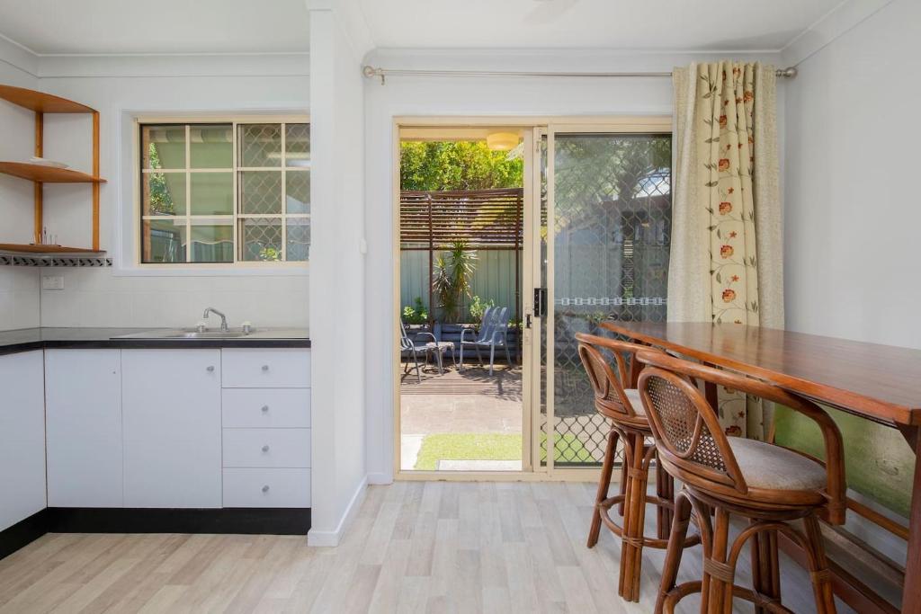 a kitchen with a counter and chairs and a table at 'The Elizabeth' A Romantic Garden Retreat for Two in Newcastle